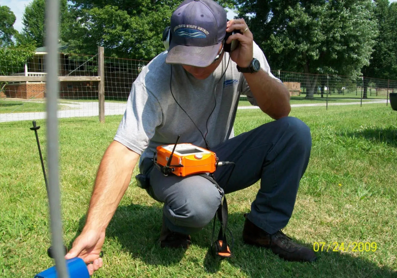 Professional leak detection technician using specialized equipment to locate an underground water leak in New York