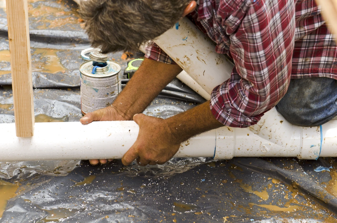 Professional plumber repairing a damaged sewer pipe for sewer repair services in New York